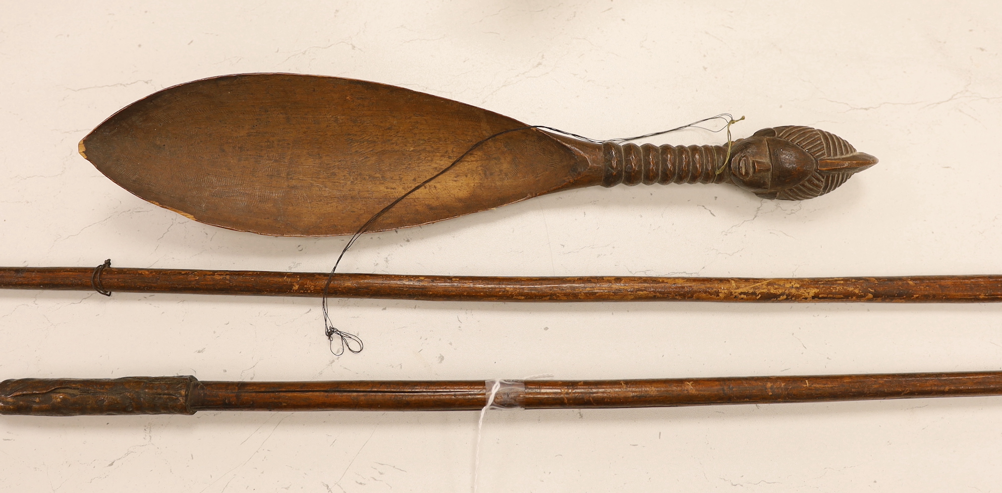Two African throwing spears and a carved spoon with figural handle, longest spear 132cm